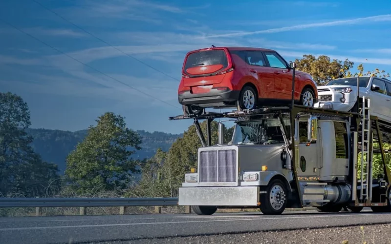 A truck haul a red car